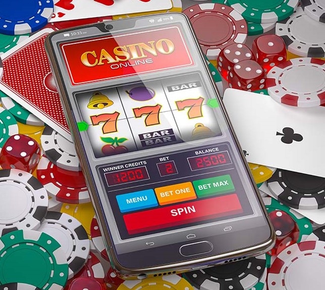 Online casino. Slot machine on smartphone screen, dice, casino chips and cards.